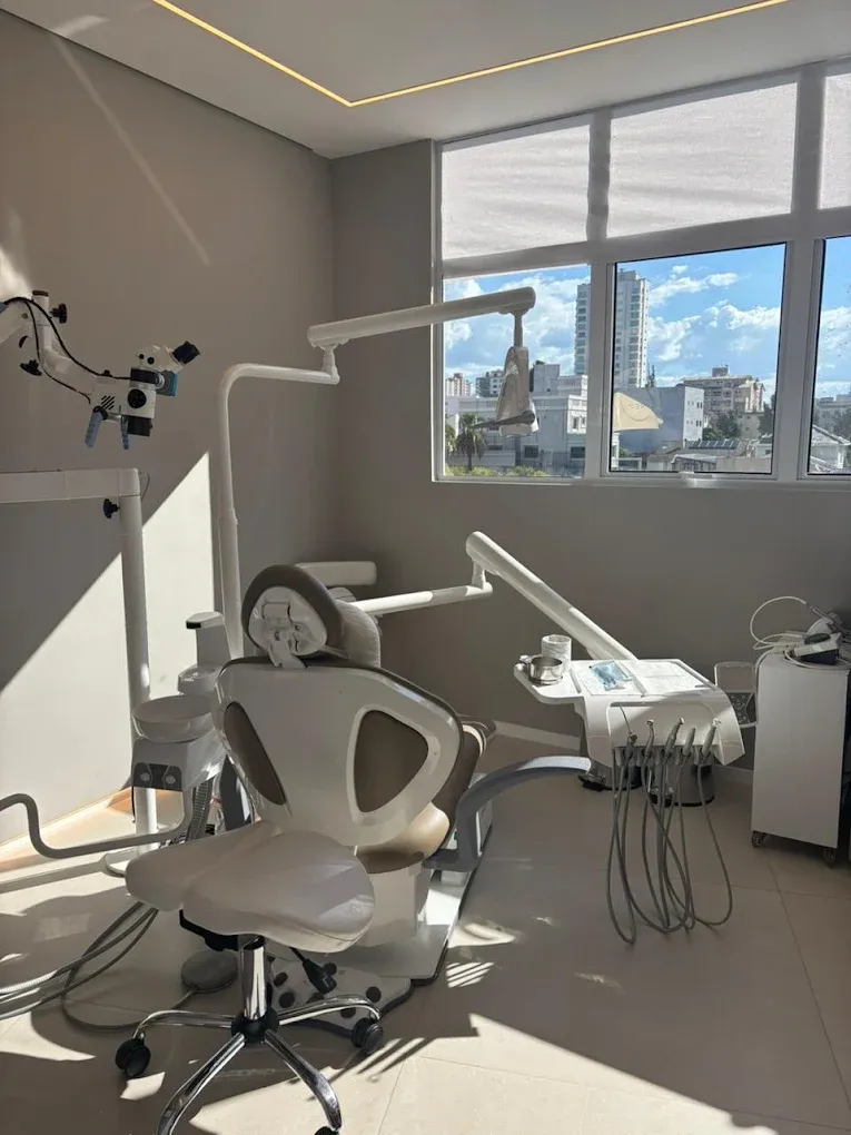 Sala de atendimento da LINEARE, com microscópio e cadeira odontológica.